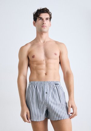 Gestreifte Boxershorts aus Baumwolle in Marineblau und Weiß, mit elastischem Bund, Knopfverschluss und lockerer Passform.