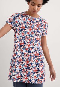 Túnica de manga corta con estampado floral que presenta una mezcla de flores rojas, rosas y azules sobre un fondo blanco. Fabricada con un tejido ligero y suave.