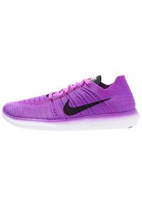 Zapatilla de running de Nike con parte superior de punto morado, logo Swoosh negro y suela blanca texturizada con acentos rosas. Diseño minimalista.