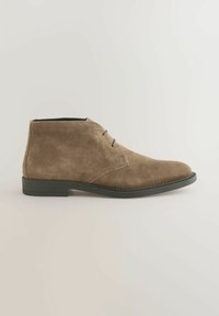Brune ruskindsankelstøvler med en glat overflade, rund tå og to snørebånd. Sort gummisål, minimalistisk design og neutral farve.