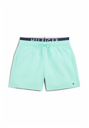 Bañador corto de hombre azul claro con cintura ajustable con cordón, bolsillos laterales y un pequeño logo de la bandera de Tommy Hilfiger en la pierna izquierda.