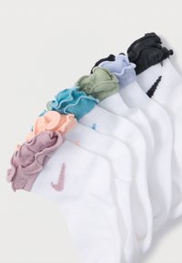 Sada šesti kotníkových ponožek s volánkovým lemem. Barvy zahrnují bílou, růžovou, modrou, zelenou, šedou a černou. Bavlněná směs s akcenty loga Nike.