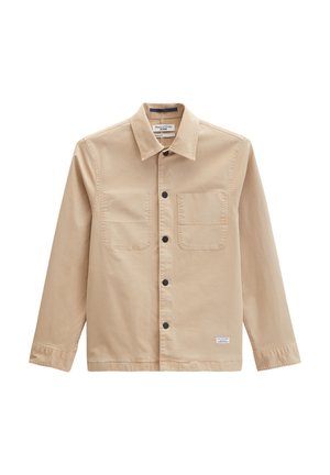 Beige langärmliges Hemd mit Knöpfen, Kragen, zwei Brusttaschen, schwarzen Knöpfen und einem kleinen weißen Etikett nahe dem Saum.