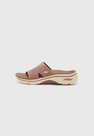 Pink mesh slide sandal with two wide straps, curved beige sole, and textured footbed featuring a wave pattern. ArchFit branding visible.