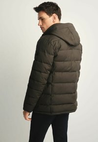 Puchowa kurtka w ciemnozielonym kolorze z kapturem, z segmentowym wypełnieniem, gładkim wykończeniem i logo na lewym ramieniu.