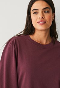 Bordeaux lange mouwen shirt met een ronde hals en details van puffed schouders. Soepele textuur en casual pasvorm, geschikt voor dagelijks gebruik.