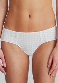 Mutandine bianche a scacchi con accenti di ricamo floreale sui lati, realizzate in tessuto morbido, dotate di un cinturino liscio e di un design aderente.
