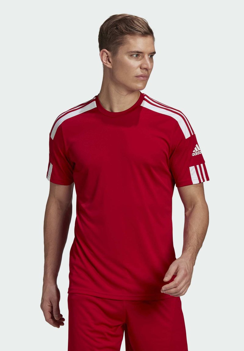 Maglietta sportiva rossa con strisce bianche sulle spalle, realizzata in materiale leggero, con colletto a girocollo e maniche corte. Logo Adidas sulla manica.
