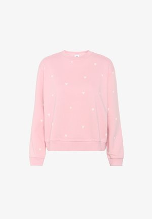 Ružový sveter s okrúhlym výstrihom, ktorý obsahuje malé biele srdiečkové vzory po celom povrchu, rebrované manžety a uvoľnený strih na spodnej časti.