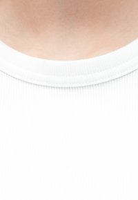 Λευκό ύφασμα με ριμπ ύφανση, στρογγυλή γραμμή λαιμού με διακριτική ραφή, λεία υφή. Κοντινή λήψη που εστιάζει στην περιοχή του γιακά.