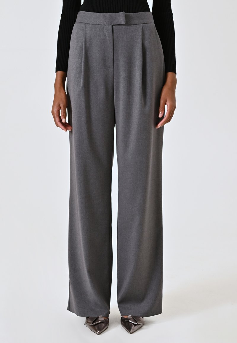 Grijze wijde broek met plooien, een middelhoge tailleband, een taillering en een gladde textuur. Gecombineerd met schoenen met een spitse neus en hak.