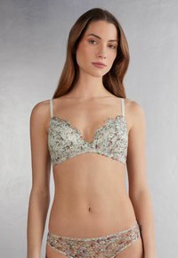 Bloemenkant bralette met een gescandeerde halslijn, in groene, roze en paarse tinten. Bijpassende bloemenpatroon onderbroek.