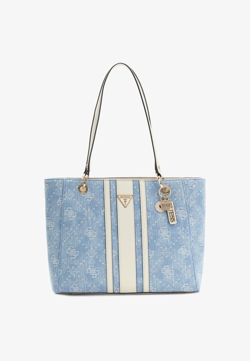 Sac tote en denim bleu clair avec des rayures verticales blanches, double bretelles et breloques métalliques à logo Guess suspendues sur un côté.