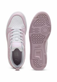 PUMA sneakers featuring a white leather upper with soft pink accents, round toe, perforated details, and a textured pink rubber sole.