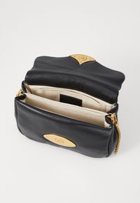 Borsa a tracolla in pelle nera con hardware dorato, dotata di patta pieghevole, due scomparti interni e una finitura testurizzata.
