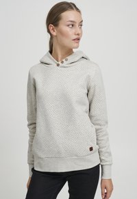 Felpa con cappuccio grigia chiara con piccoli punti neri, dotata di cordoncino, due bottoni decorativi e polsini e orlo a coste.