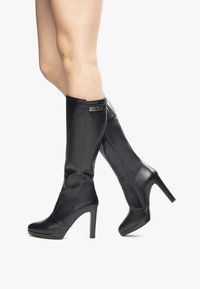 Black leather knee-high boots with a sleek design, pointed toe, high heel, and strap accents at the top. Smooth texture with minimal detailing.