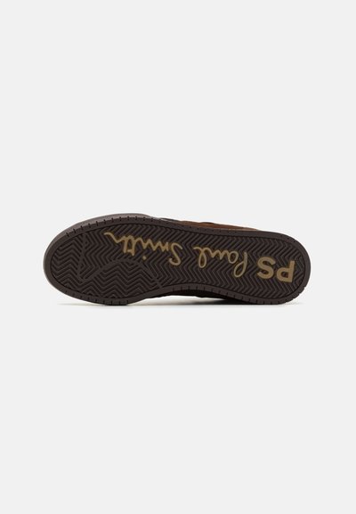 Brown sneaker sole with a rubber herringbone pattern, featuring a gold "PS" logo and stylized script, curved edge, and textured finish.