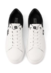 Sneakers bianchi in pelle con punta rotonda, dettagli neri sul tallone e lacci piatti. Presentano un logo di lato e una parte superiore testurizzata.