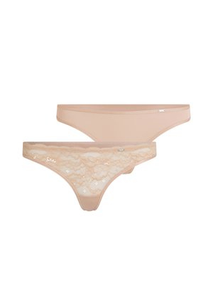 Deux strings beiges pour femmes, l'un en tissu uni lisse et l'autre avec un devant en dentelle florale, tous deux avec de petites étiquettes de logo sur la ceinture.