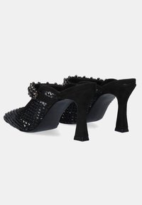 Mules negros con un diseño trenzado, puntera puntiaguda texturizada y un tacón resistente. Decorados con acentos decorativos en un acabado brillante.