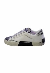 Zapatillas blancas con una punta plateada brillante, detalles en negro y un estampado de animal texturizado en el talón. Material de cuero suave.