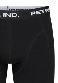 Schwarze Baumwoll-Boxershorts mit einem weichen, elastischen Bund, der weiße Schriftzüge aufweist. Glatte Textur mit genähten Details an den Seiten.