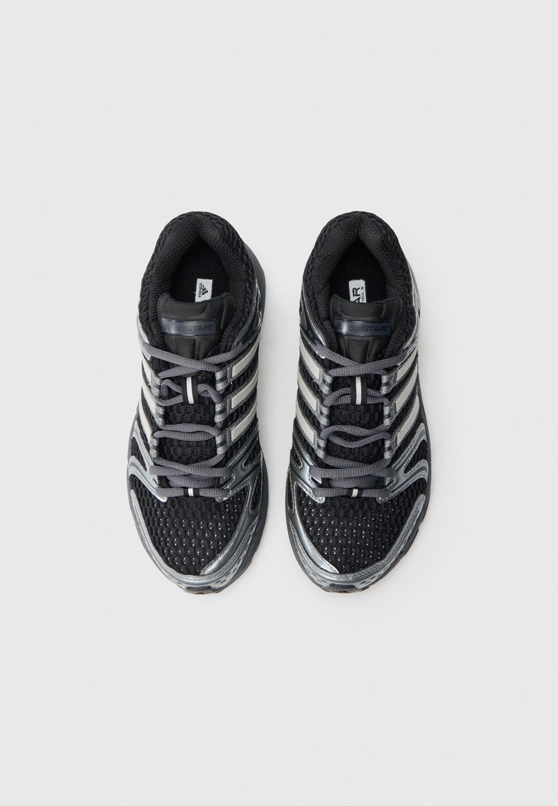Scarpe sportive nere con tomaia in mesh, dettagli argentati e lacci grigi. Presentano una suola texturizzata e un puntale rinforzato per maggiore durata.