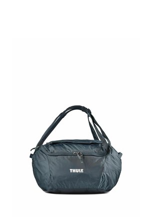 Dark gray Thule duffel bag with adjustable shoulder strap and front zipper pocket on a white background.