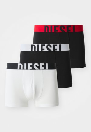 Tres pares de calzoncillos tipo bóxer Diesel: uno blanco con cinturilla negra, uno negro con cinturilla gris y uno negro con cinturilla roja.