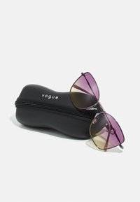 Ochelari de soare Vogue cu lentile violet în degrade, într-o formă unghiulară, așezați pe un etui rigid negru cu fermoar și logo alb.