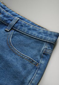 Tepet de denim albastru, cu o textură netedă, având cusături portocalii contrastante, un tiv și un detaliu de buzunar frontal.