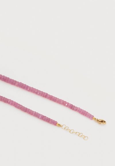 Λεπτό ροζ κολιέ με διακοσμητικές χάντρες και χρυσό κούμπωμα τύπου «καβουράκι» με ρυθμιζόμενο αλυσίδα, σε λευκό φόντο.
