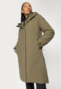 Parka lunga color verde oliva con cappuccio, dotata di chiusura con zip, tasche laterali e tessuto testurizzato. Progettata per calore e comfort.