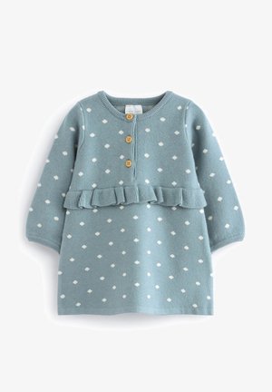 Robe tricotée bleu clair à pois blancs, taille froncée avec volants, et trois boutons en bois à l'avant. Manches longues et col rond.