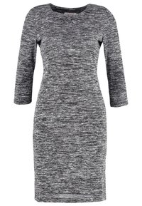 Stickad klänning i svart- och vitmelerad mönster; har en rundad halsringning och trekvartsärmar; kroppsnära silhuett.