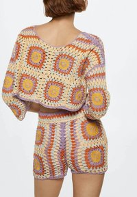 Conjunto de dos piezas de punto de ganchillo que incluye una parte superior cuadrada y pantalones cortos de cintura alta. Hecho de hilo multicolor en tonos pastel y cálidos con patrones florales.
