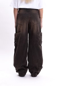 Brązowe spodnie cargo o luźnym kroju, z dużymi bocznymi kieszeniami i widocznymi detalami szycia, wykonane z miękkiego materiału przypominającego denim.