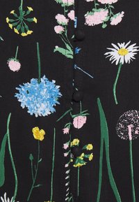 Robe noire à fleurs avec des motifs colorés en bleu, rose, blanc et jaune, dotée d'une fermeture à boutons et d'accents semblables à de l'herbe verte.