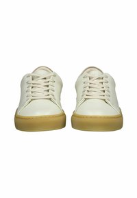 Basket en cuir blanc avec une finition texturée, bouts ronds et semelles en caoutchouc beige. Dispose de lacets assortis et d'un design minimaliste.