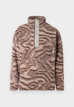 Rjavi in bež pulover iz flisa z vzorcem, stoječim ovratnikom, gumbno zaporo in žepom na prsih z zadrgo na enobarvnem ozadju.