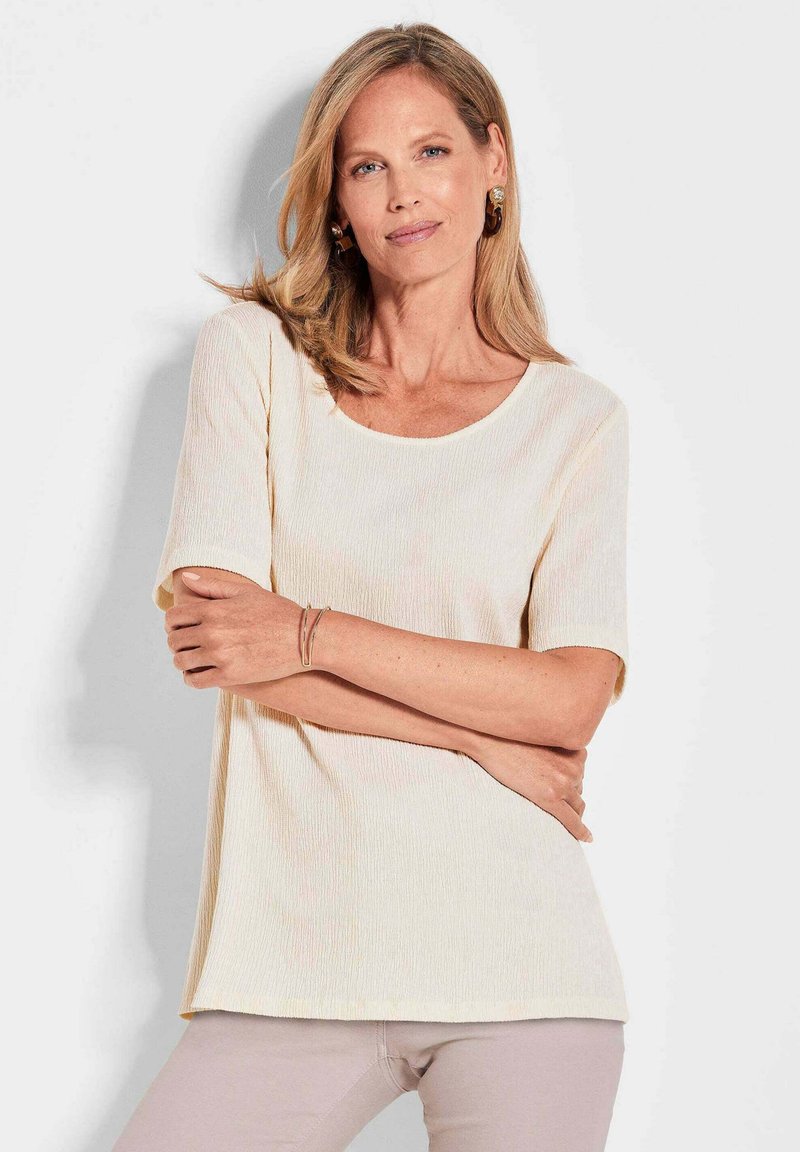 Cremfarbener, gerippter Kurzarm-Top mit rundem Ausschnitt und lockerer Passform. Verfügt über eine dezente Textur und einen geraden Saum.