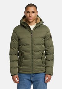 Green padded jacket with a zip closure and hood, featuring a beige fleece lining, two front pockets, and logo patch on the sleeve.