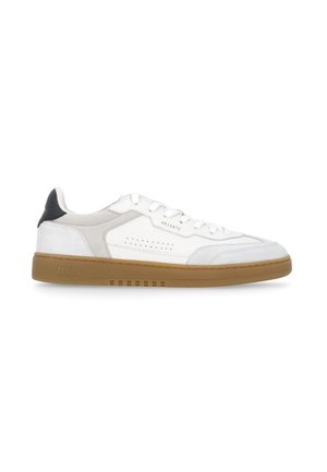 Sneaker bianca low-top con dettagli beige, suola in gomma color cuoio, linguetta nera sul tallone e marchio "Arigato" sul lato e sulla suola.
