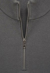 Grå dragkedja tröja med hög ribbad krage, med en hel längd metall dragkedja och en slät stickning.