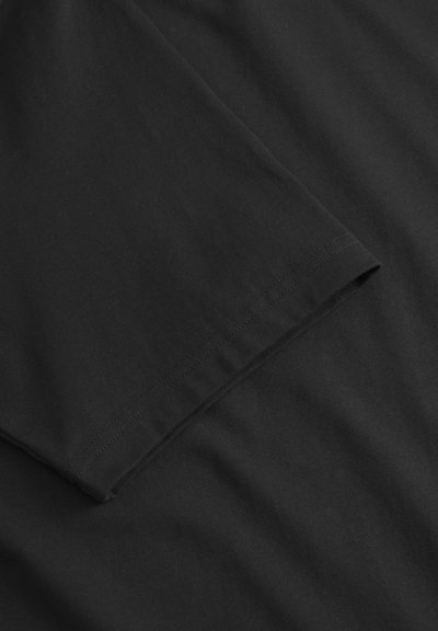 Tricou negru din bumbac cu guler rotund și mâneci scurte. Textură netedă cu detalii cusute pe mâneci, având un design de culoare uniformă.