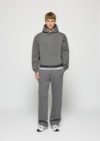 Gray sweatshirt with a hood and kangaroo pocket, paired with matching sweatpants. Smooth texture and relaxed fit; white inner layer visible.