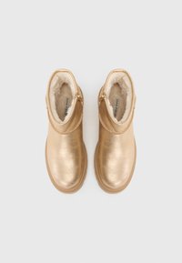 Zlaté členkové topánky s metalickým povrchom a mäkkou vnútornou podšívkou. Jemne textúrovaný povrch a bočný zips. Dizajn s okrúhlou špičkou.