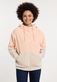 Gevoerde jas met een ritssluiting. Beschikt over een geribbelde textuur in roze en beige secties. Voorzakken inbegrepen, met verstelbare koordjes.