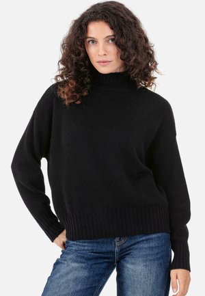Pull noir à col roulé avec poignets et ourlet côtelés, confectionné dans un matériau tricoté doux. Coupe décontractée, avec épaules tombantes pour plus de confort.